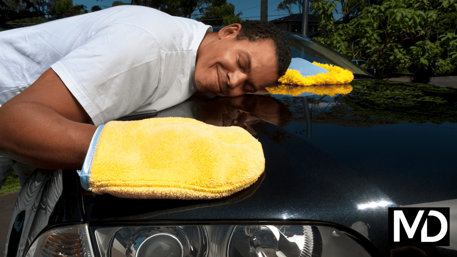 a man sleeping on a car hood