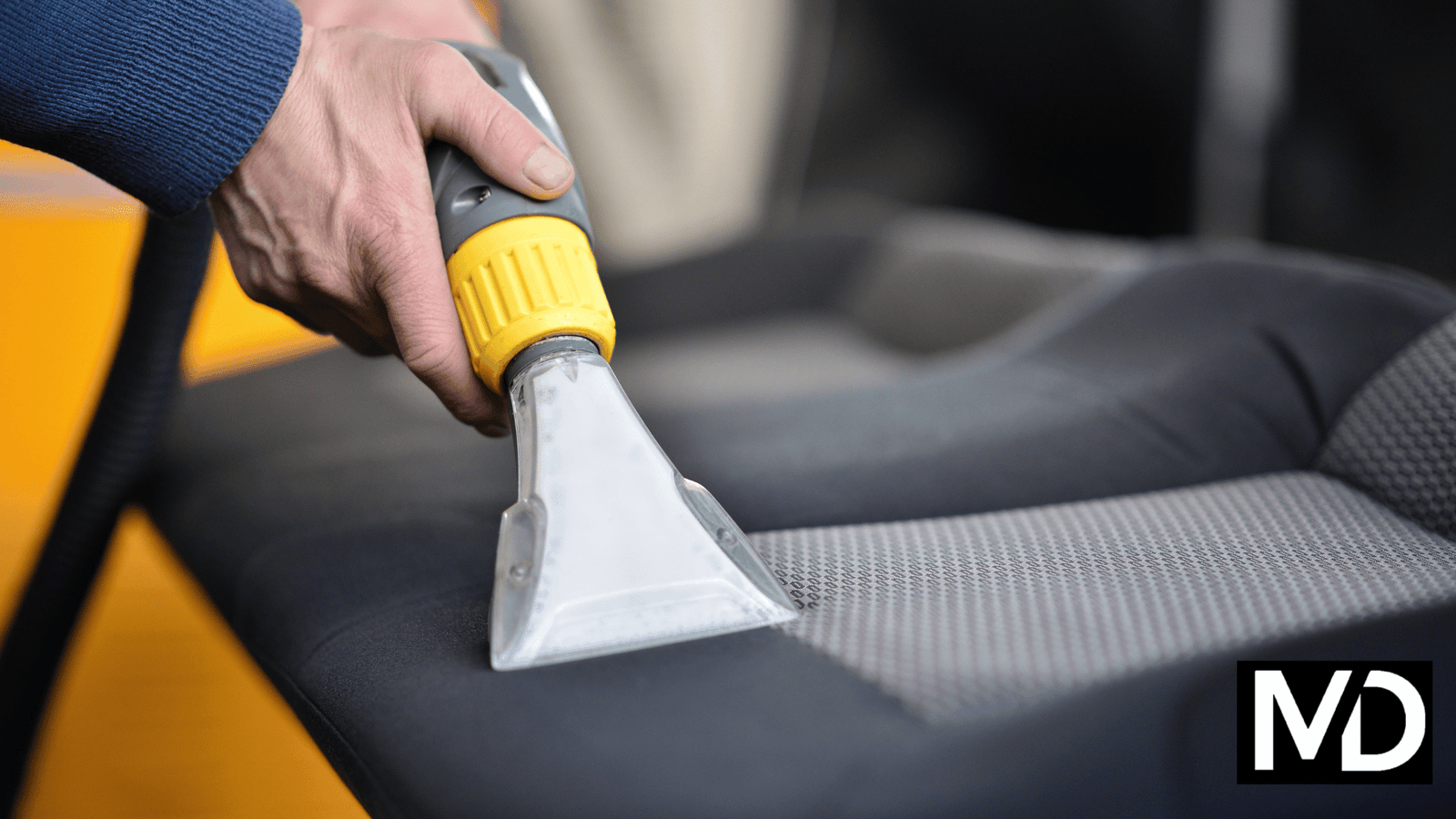 a person vacuuming a seat